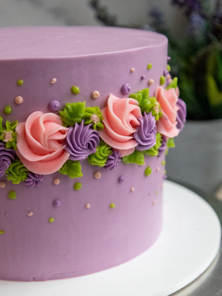 伯爵灰色薰衣草层蛋糕的图像，装饰着奶油花