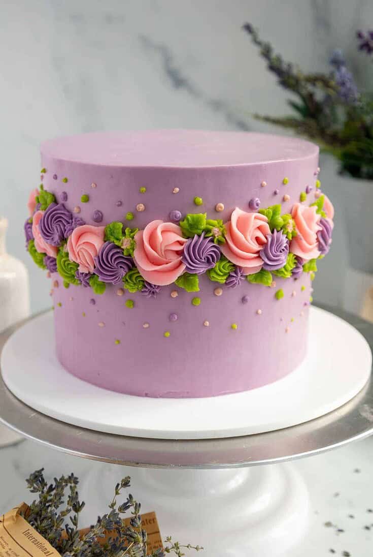 伯爵灰色薰衣草层蛋糕的图像，装饰着奶油花